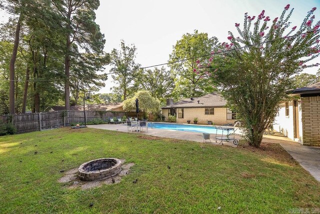 view of yard with an outdoor fire pit and a fenced in pool