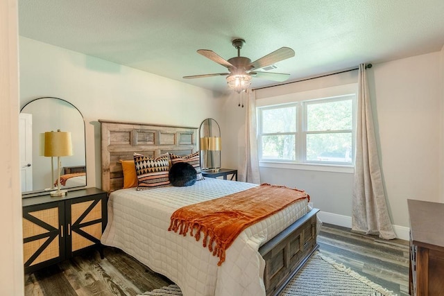 bedroom with dark wood-style flooring, ceiling fan, a textured ceiling, and baseboards