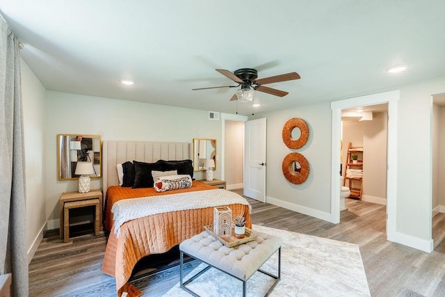 bedroom with visible vents, baseboards, and wood finished floors