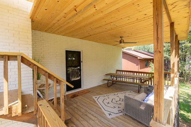 deck featuring a ceiling fan and stairway