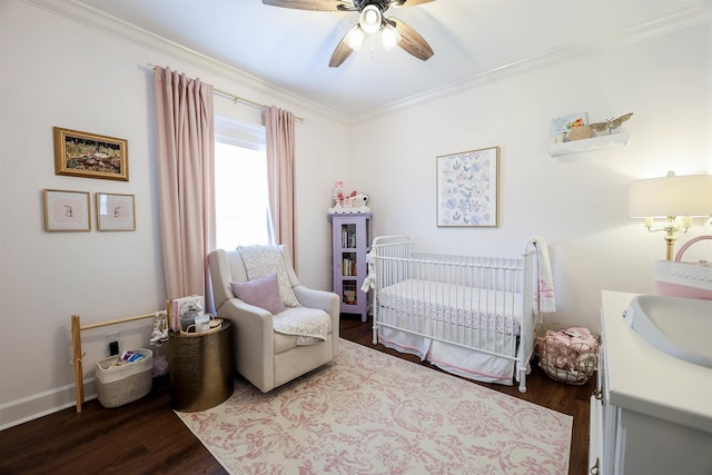 bedroom featuring a crib, ceiling fan, dark hardwood / wood-style flooring, ornamental molding, and sink