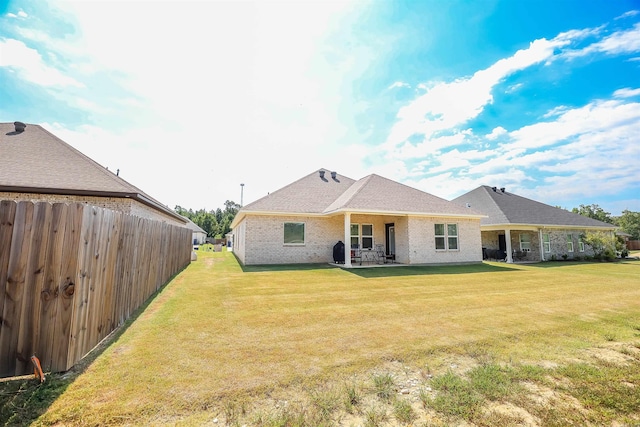 rear view of house featuring a yard