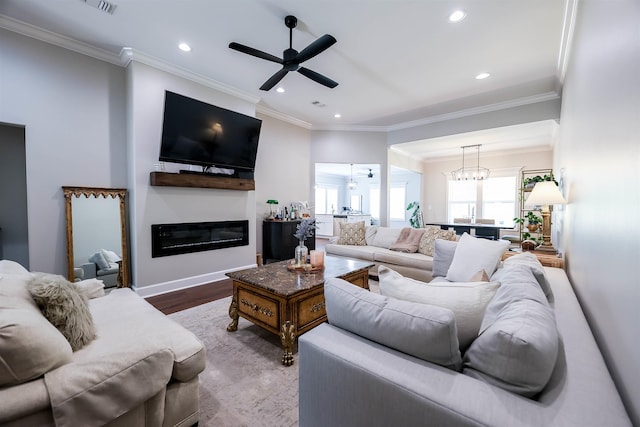 living room featuring ornamental molding, hardwood / wood-style floors, and ceiling fan with notable chandelier