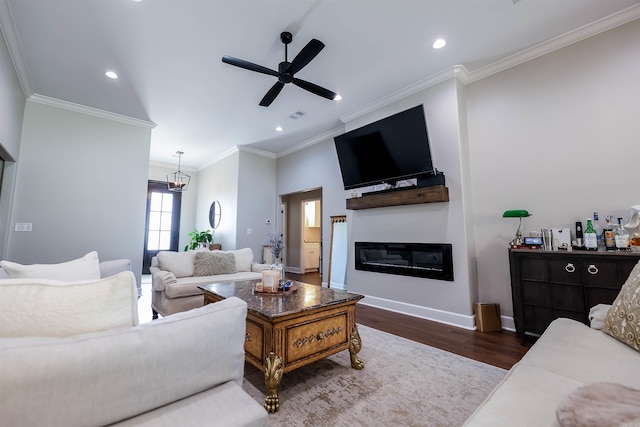 living room with ceiling fan with notable chandelier, dark hardwood / wood-style flooring, and ornamental molding