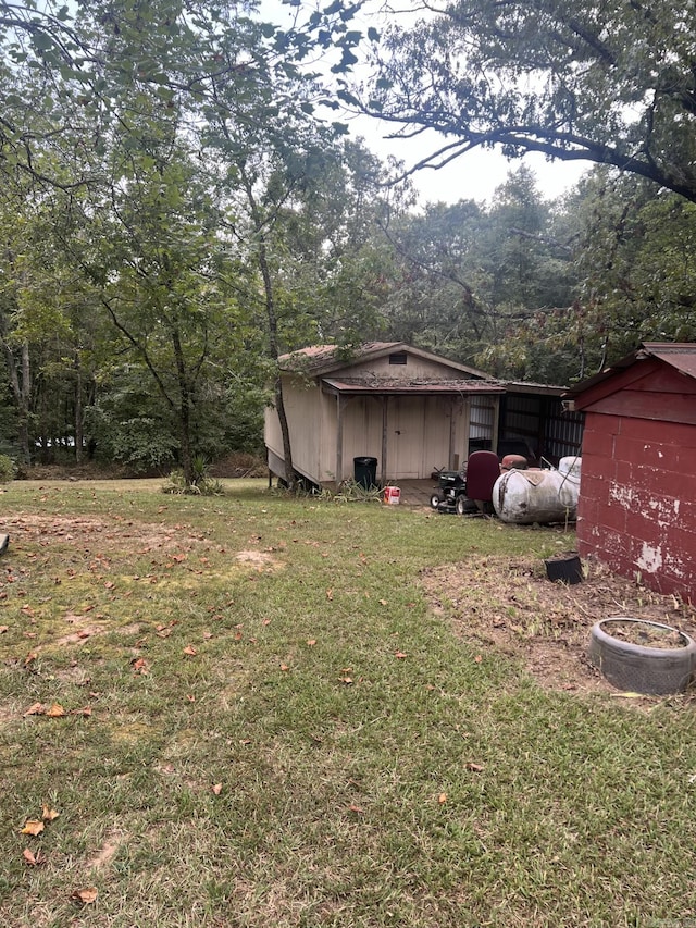 view of yard with an outdoor structure and a view of trees