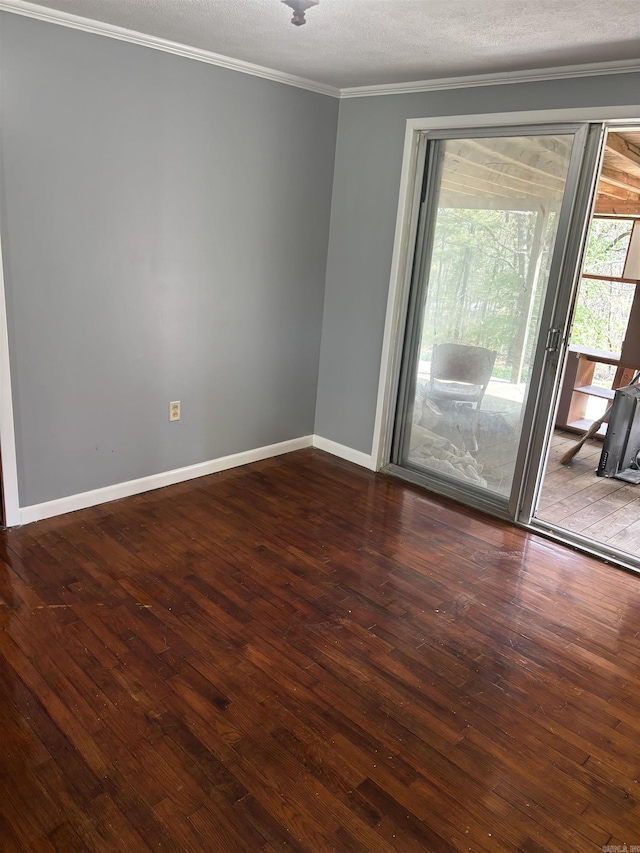 empty room featuring hardwood / wood-style floors, a textured ceiling, baseboards, and crown molding