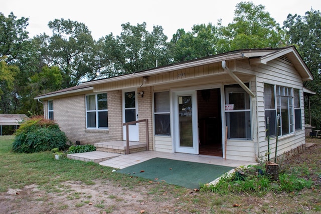 view of front facade featuring a patio and brick siding