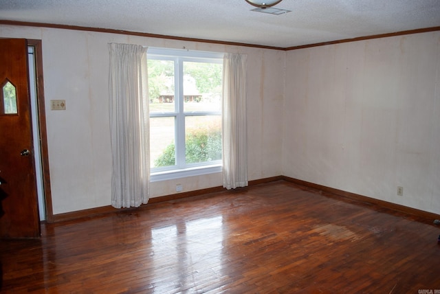 spare room with a textured ceiling, ornamental molding, and hardwood / wood-style floors