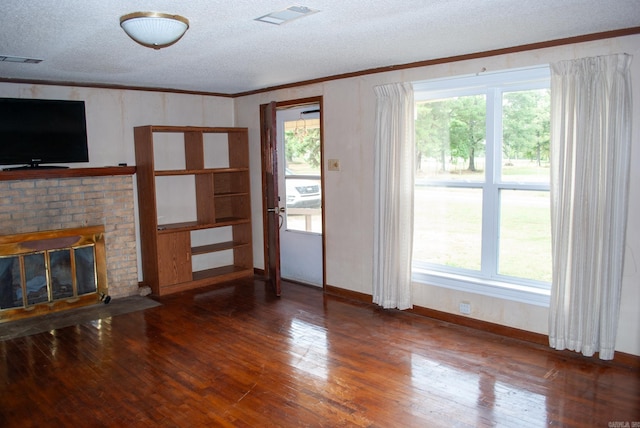 unfurnished living room featuring ornamental molding, wood-type flooring, and a wealth of natural light