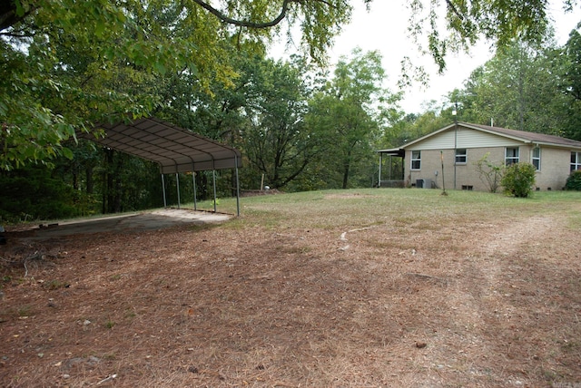 view of yard with driveway and a detached carport