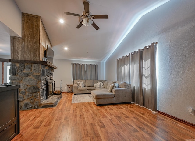 living room featuring ceiling fan, a fireplace, hardwood / wood-style flooring, and a healthy amount of sunlight