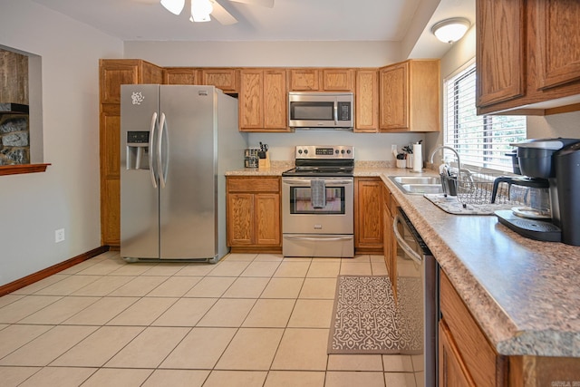 kitchen with sink, stainless steel appliances, ceiling fan, and light tile patterned flooring