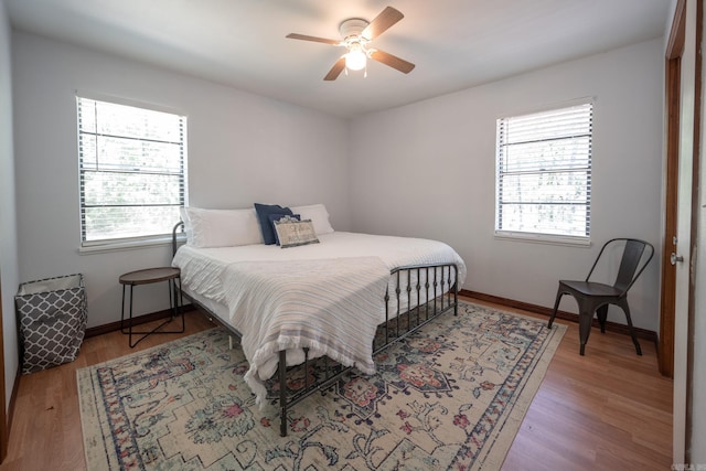 bedroom with multiple windows, light hardwood / wood-style flooring, and ceiling fan