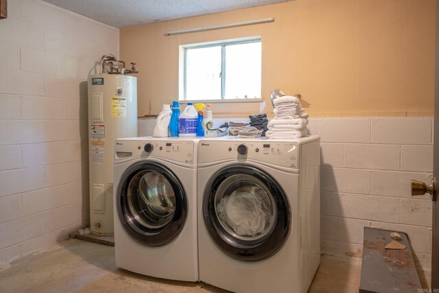 laundry area with washing machine and dryer, a textured ceiling, and electric water heater