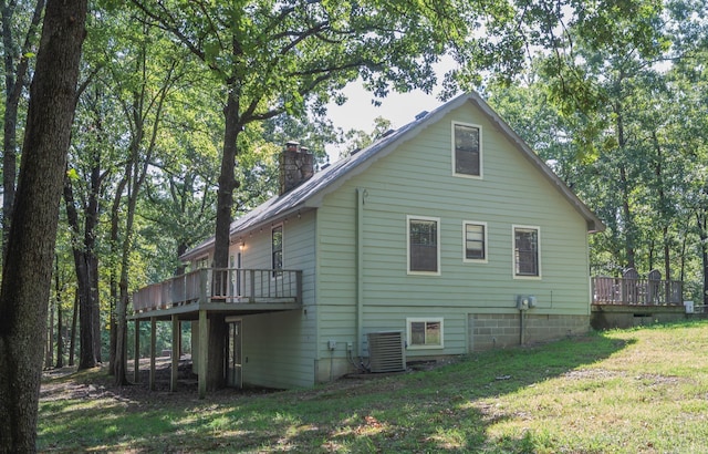 view of side of home featuring a lawn, central air condition unit, and a deck