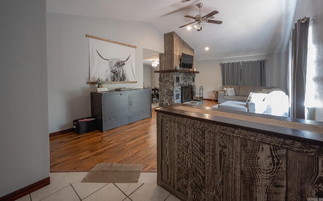 interior space featuring hardwood / wood-style floors, lofted ceiling, ceiling fan, and a fireplace