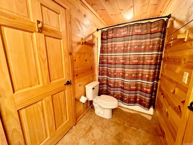 bathroom with tile patterned flooring, wood walls, wooden ceiling, and toilet