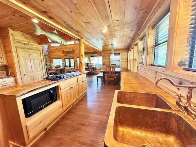 kitchen featuring light brown cabinets, butcher block counters, wooden walls, and hardwood / wood-style floors