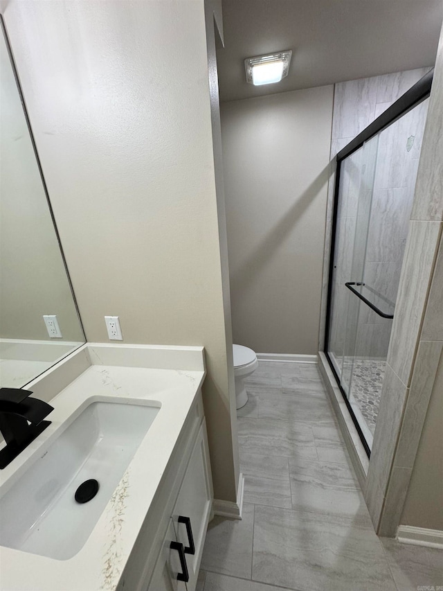 bathroom with vanity, a shower with shower door, and toilet