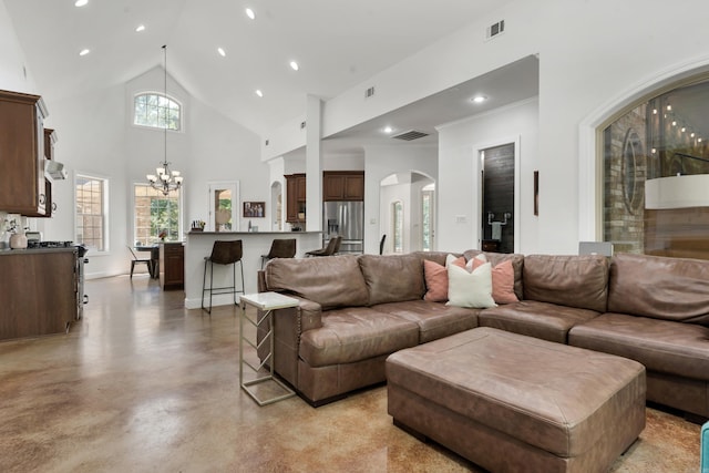 living room featuring high vaulted ceiling and a chandelier