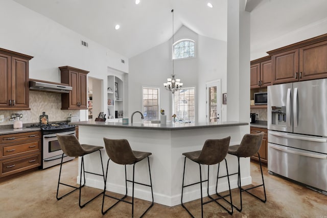 kitchen featuring appliances with stainless steel finishes, backsplash, an inviting chandelier, high vaulted ceiling, and a breakfast bar area