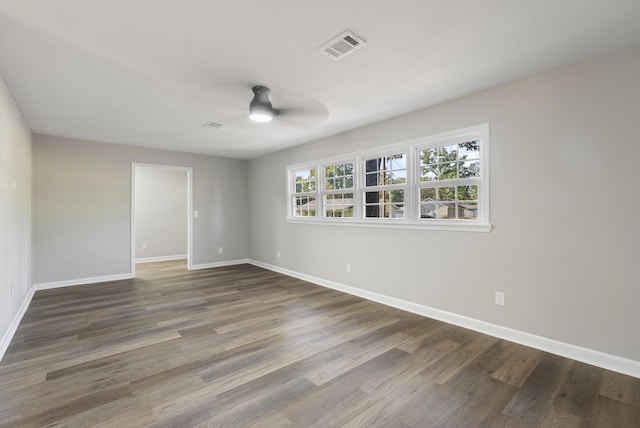 empty room with baseboards, visible vents, ceiling fan, and wood finished floors