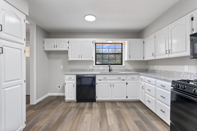 kitchen featuring a sink, white cabinetry, light stone countertops, black appliances, and dark wood finished floors