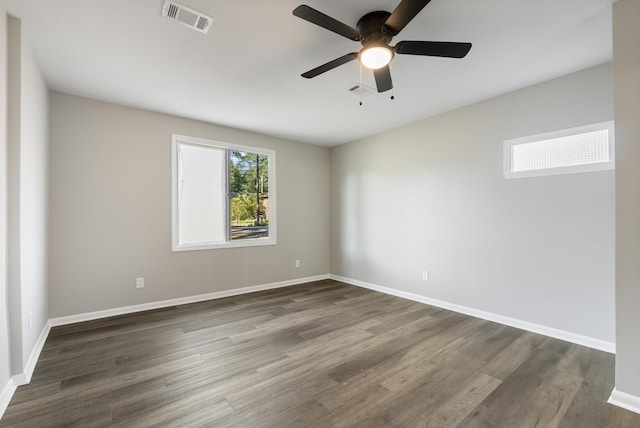 unfurnished room with ceiling fan, dark wood-type flooring, visible vents, and baseboards