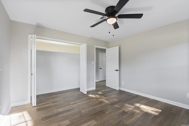 unfurnished bedroom with dark wood-type flooring, a closet, ceiling fan, and baseboards