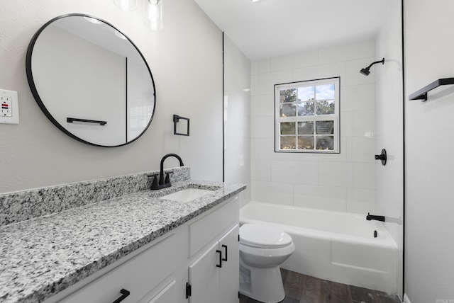 bathroom with toilet, washtub / shower combination, wood finished floors, and vanity