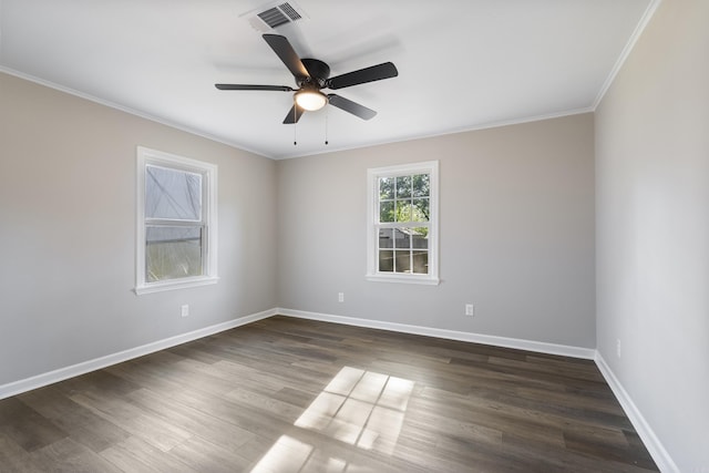 spare room featuring crown molding, dark wood finished floors, visible vents, and baseboards