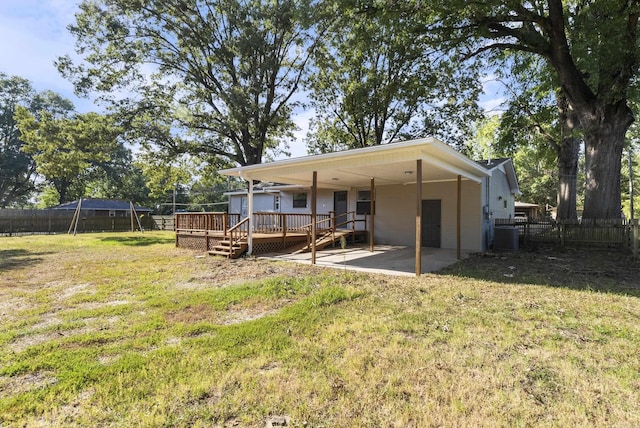 back of house featuring a patio, a fenced backyard, a trampoline, a deck, and a yard