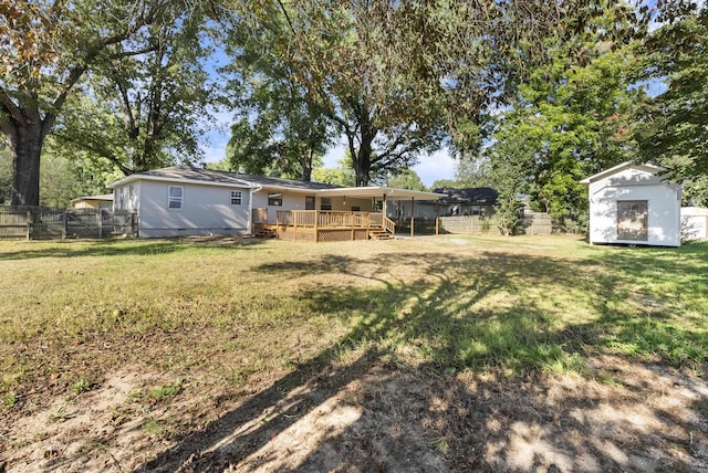 view of yard featuring an outbuilding, a fenced backyard, a wooden deck, and a shed