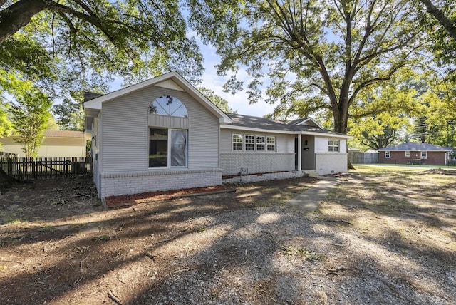 view of front of property featuring fence and brick siding