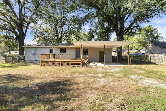 rear view of house with a deck, an attached carport, a fenced backyard, a yard, and crawl space