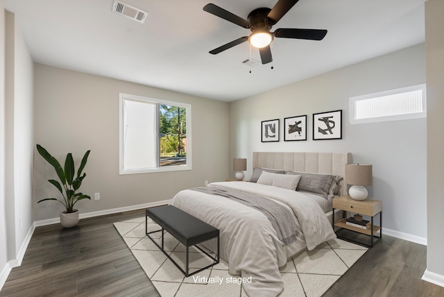 bedroom with ceiling fan, baseboards, visible vents, and dark wood finished floors