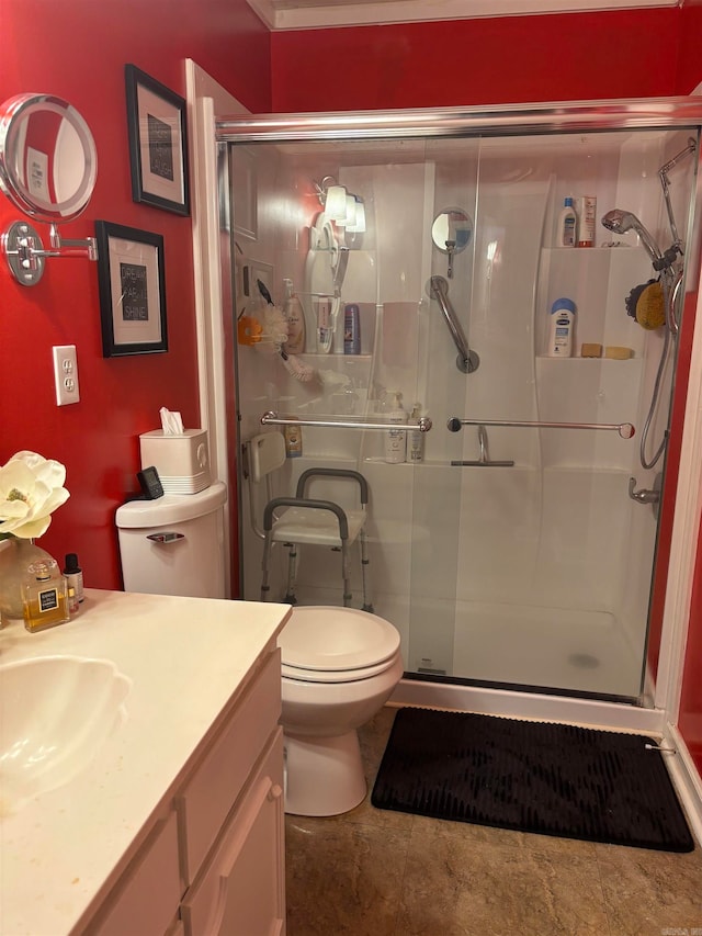 bathroom featuring tile patterned floors, a shower with door, vanity, and toilet