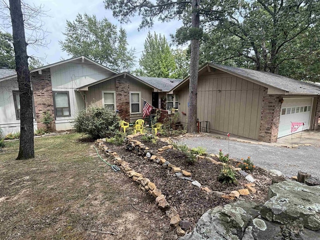 view of front facade featuring brick siding, an attached garage, and gravel driveway