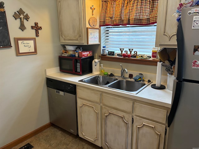 kitchen with sink, stainless steel appliances, tile patterned flooring, and light brown cabinetry