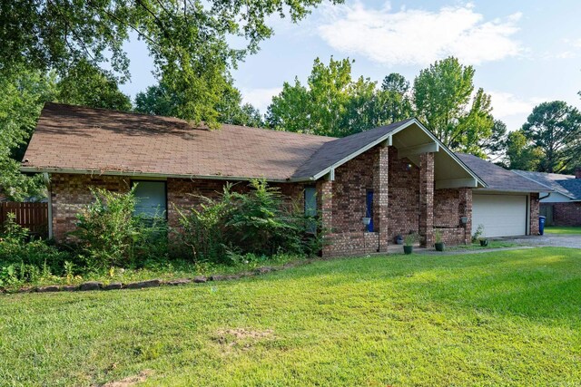 ranch-style home with a front lawn and a garage