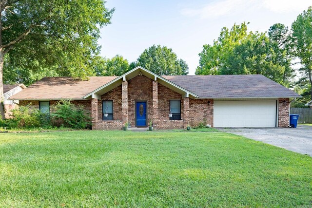 single story home with a garage and a front lawn