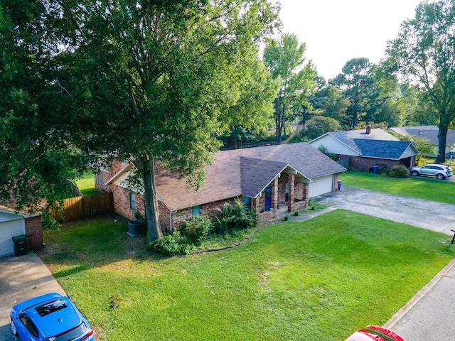 ranch-style home featuring driveway, an attached garage, fence, a front lawn, and brick siding