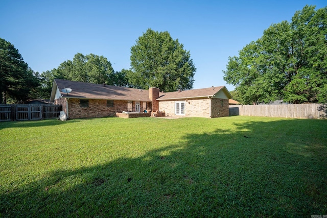 back of house featuring a lawn and fence