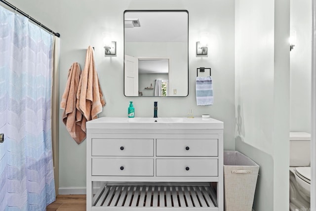 bathroom featuring toilet, a shower with shower curtain, hardwood / wood-style flooring, and vanity