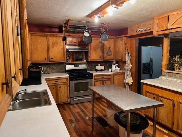 kitchen with backsplash, sink, dark wood-type flooring, a textured ceiling, and stainless steel appliances