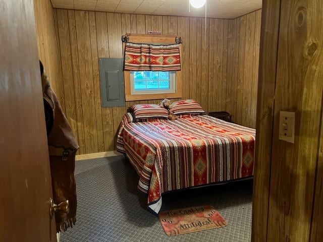 bedroom featuring wood walls and electric panel