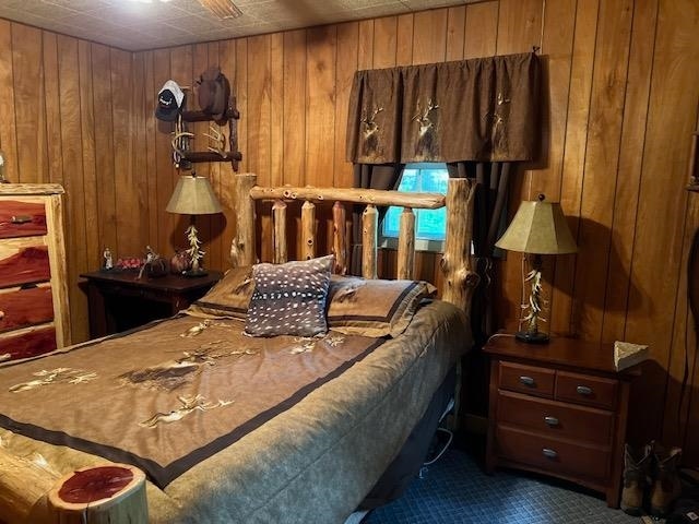 bedroom featuring carpet and wooden walls