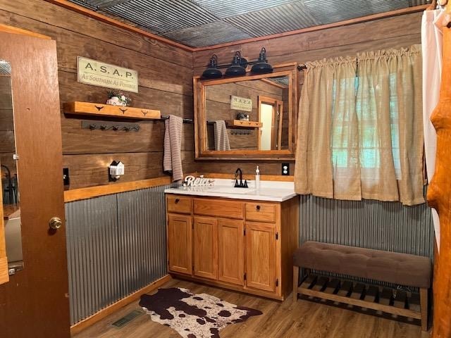 bathroom with wood walls, wood-type flooring, wooden ceiling, and vanity