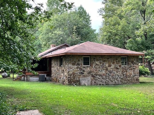 view of home's exterior with central AC unit and a lawn