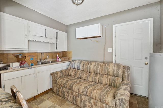 kitchen with white cabinets, sink, and light tile patterned floors